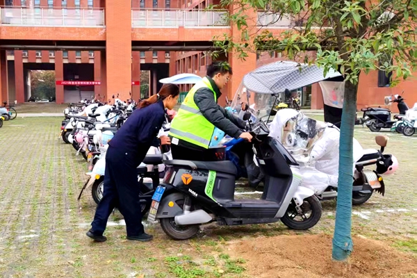 志愿服务者与保卫处工作人员在规范电动车停放_副本.jpg